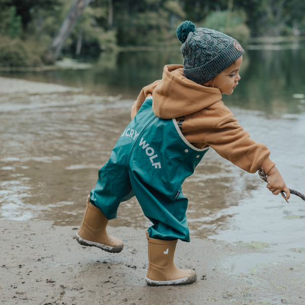 Child playing in water wearing CRYWOLF Rain Overalls Forest Green