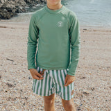 Boy wearing CRYWOLF Rash Vest - Coastal Green and Green striped boardshorts