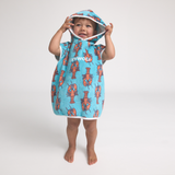 Child wearing a blue hooded towel with orange lobster patterns on a white background
