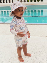 Child wearing the HUXBABY Super Dino Swim Hat and matching swimwuit side view