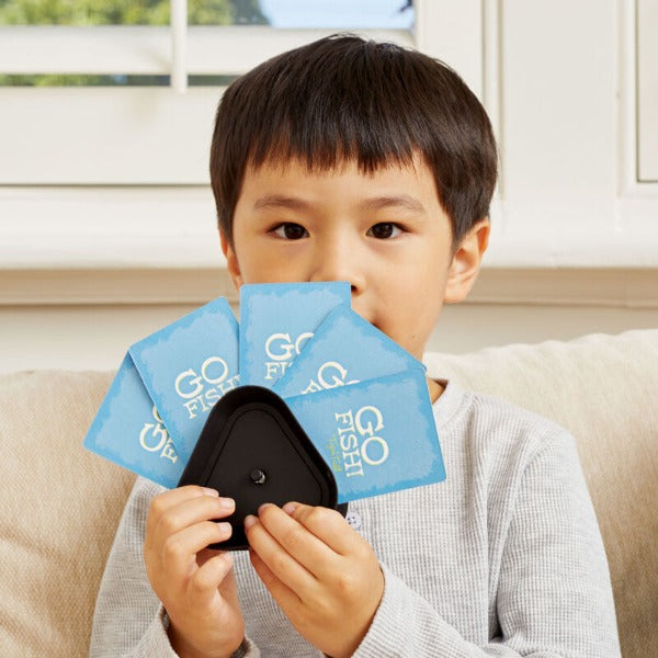 Child holding Go Fish cards