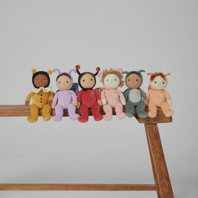 All six backyard buddies sitting on a wooden bench.  From left to right: yellow bumblebee, purple butterfly, red ladybug, pink moth, green grasshopper and orange snail
