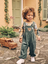 Child wearing the HUXBABY Light Spruce Cord Overalls over the T-Rex knit jumper