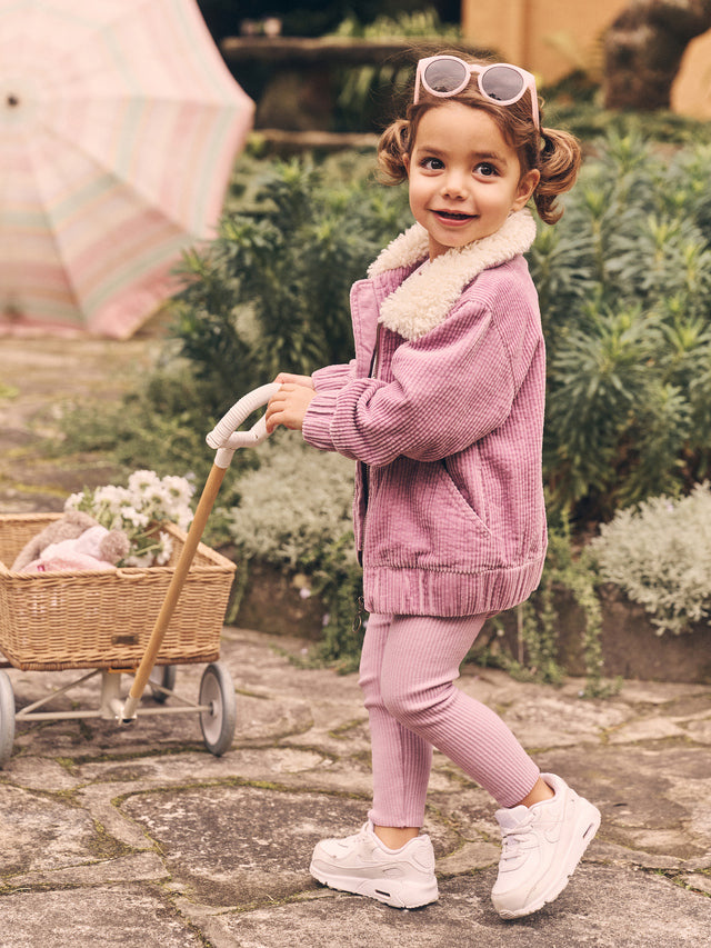 Side view of child wearing HUXBABY Orchid Rib Legging and matching cord jacket