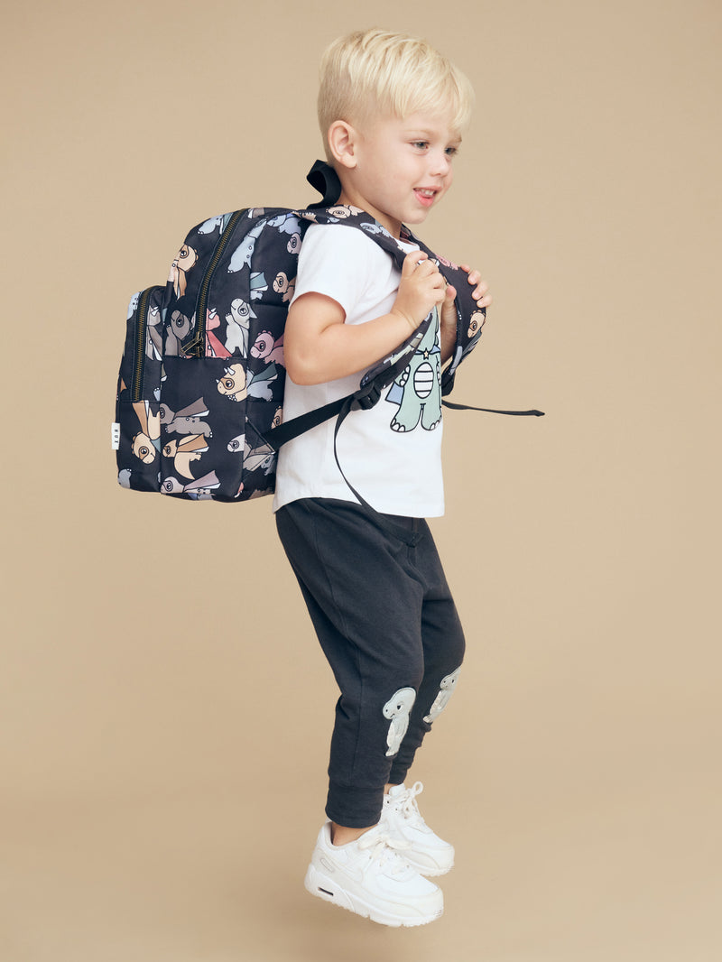 Child wearing the HUXBABY Super Dino Backpack side view