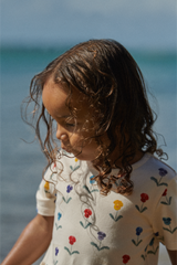 Child with wet hair standing by the ocean