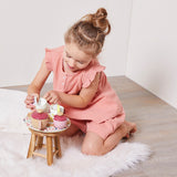 Child sitting on floor playing with JANOD Tea Set