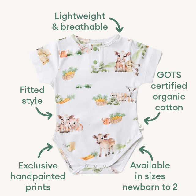 Baby onesie with animal print and certification details on a white background