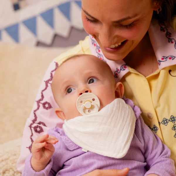 Baby sucking a BIBS dummy