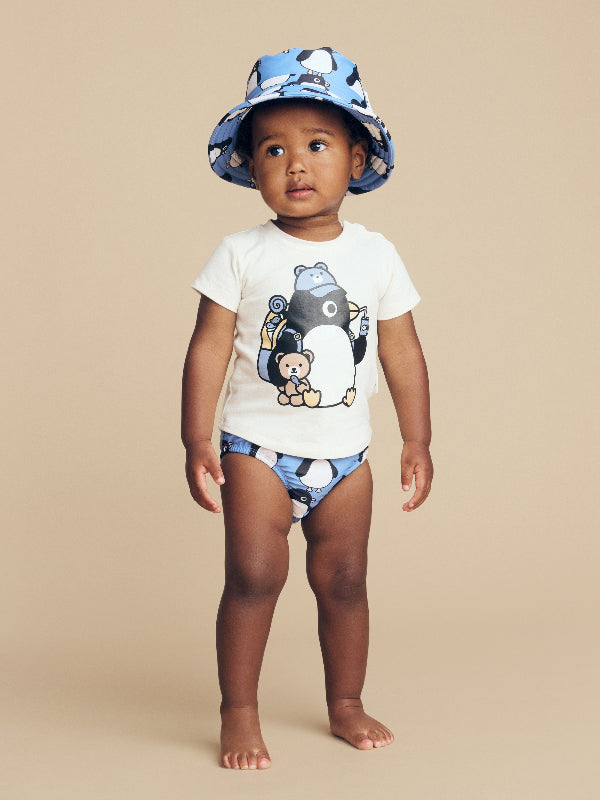 Child wearing the HUXBABY Percy Snack T-Shirt, swim nappy and hat