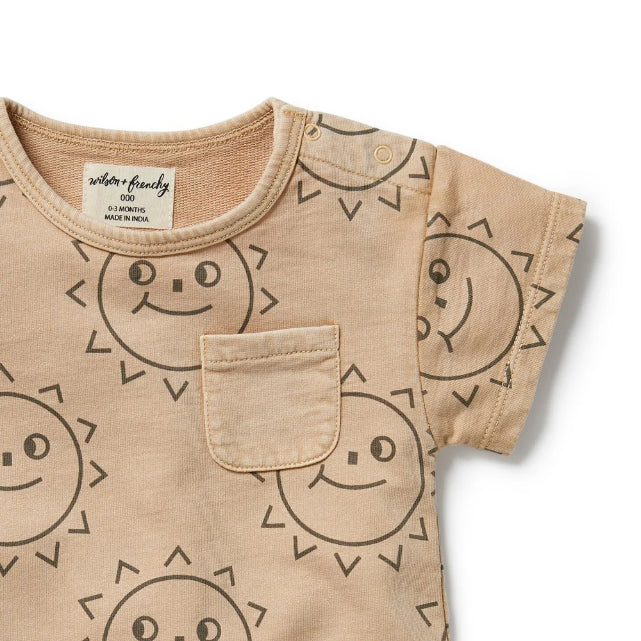 Detail view of Beige baby romper with smiley face patterns on a white background