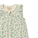 Detail view of Baby romper with green floral pattern on a white background