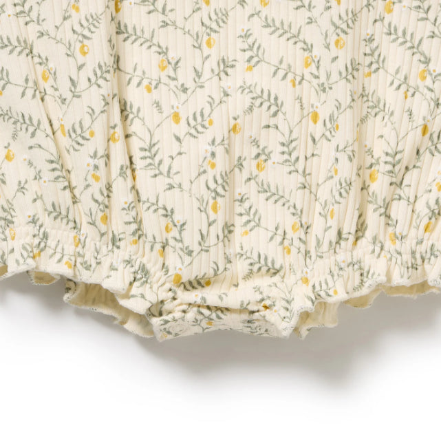 Detail view of snap crotch on Lemon Leaf patterned fabric on a white background