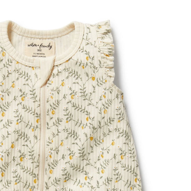 Detail view of zip closure on Baby romper with lemon leaf pattern on a white background