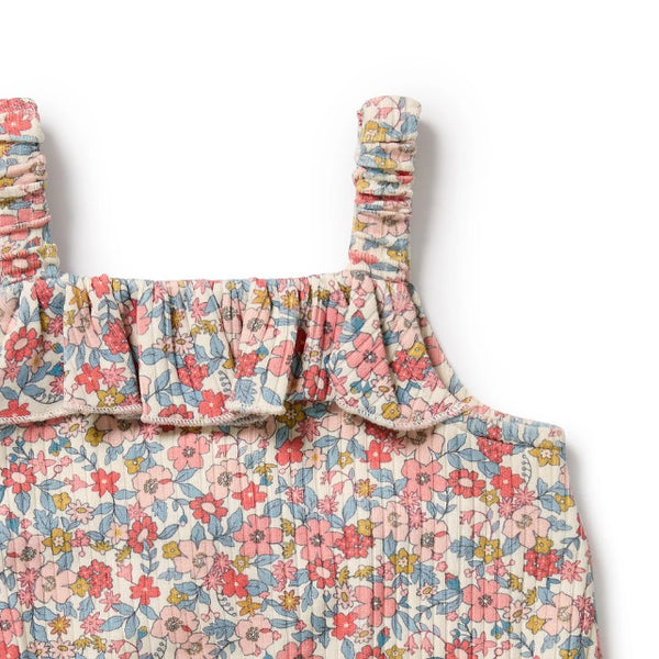 Floral patterned baby romper with ruffled straps on a white background