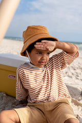 TODDLER SITTING ON SAND WEARING ACORN Terry Towelling Bucket Hat - Caramel