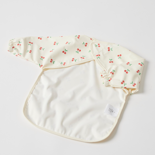 Back of Baby bib with cherry pattern on a light grey background