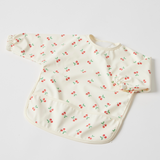 Baby bib with cherry pattern on a light gray background