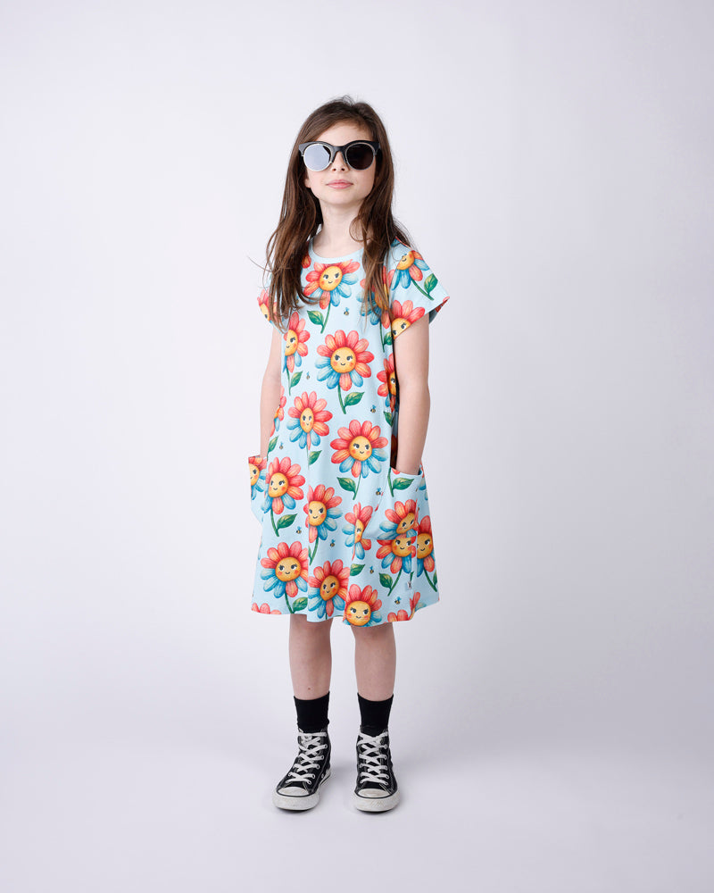 Young girl wearing a floral dress with cartoon characters on a white background