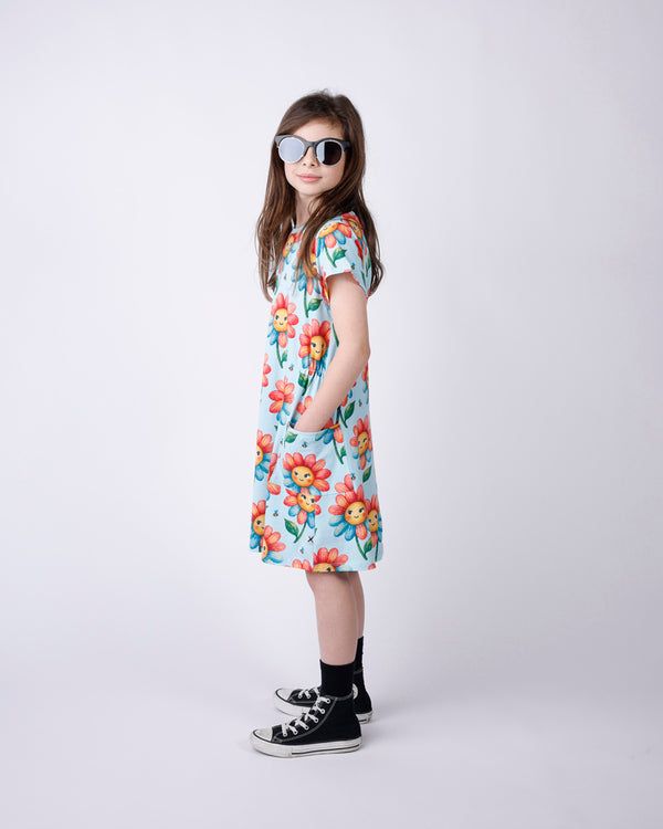 Young girl wearing a floral dress and sunglasses on a white background