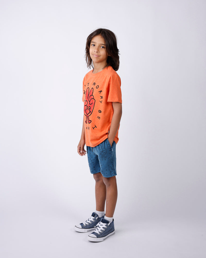 Child wearing an orange t-shirt with a graphic design and blue shorts on a white background