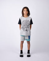 Child wearing a graphic t-shirt and shorts on a white background