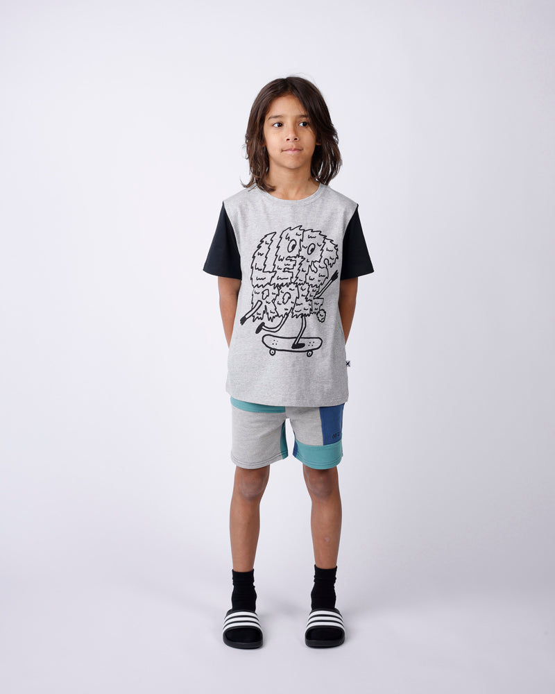 Child wearing a graphic t-shirt and shorts on a white background