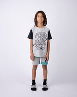 Child wearing a graphic t-shirt and shorts on a white background