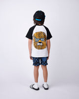 Child wearing a black and white tee shirt with a graphic design, checkered shorts, and a cap on a white background