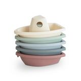 Stack of colourful plastic boats on a white background