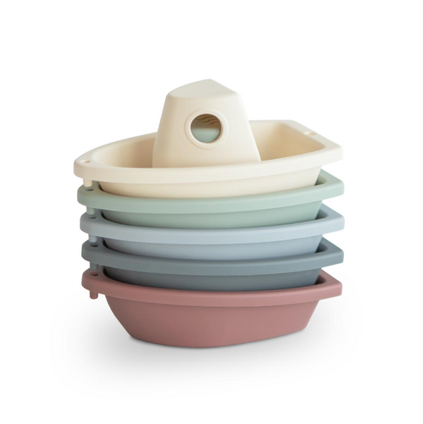 Stack of colourful plastic boats on a white background