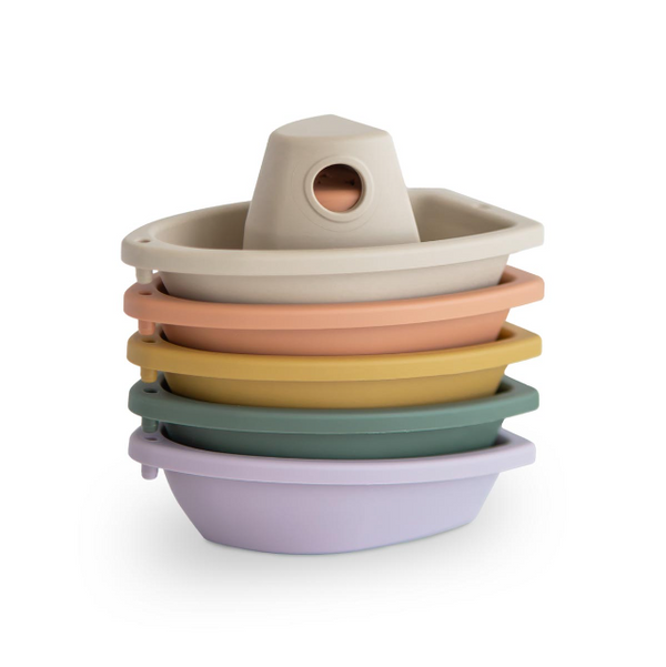Stack of colourful plastic boats on a white background