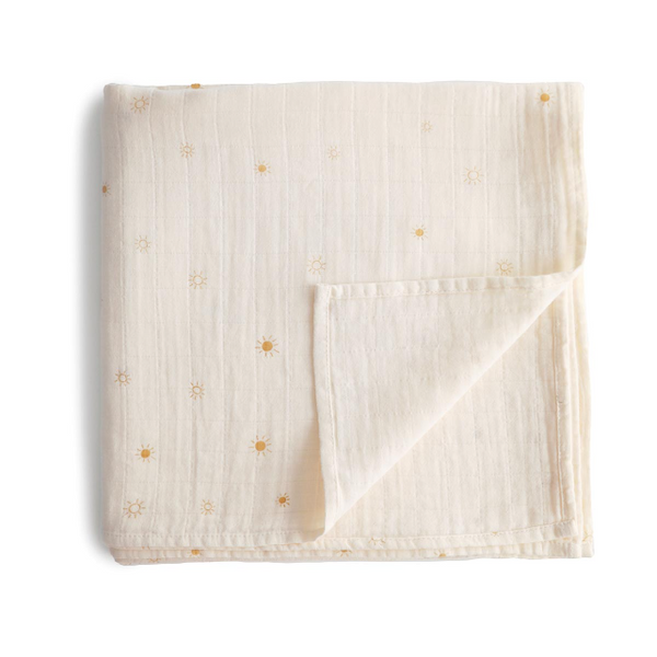 Folded beige fabric with small yellow sun print on a white background