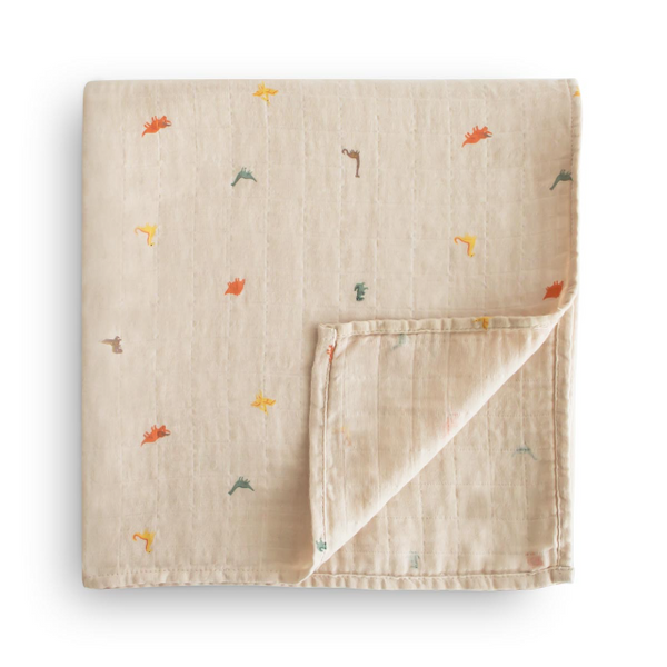 Beige baby blanket with small colourful dinosaur prints on a white background