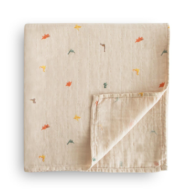 Beige baby blanket with small colourful dinosaur prints on a white background