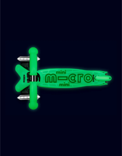 Green mini micro scooter on a black background