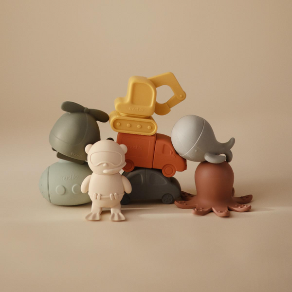 Set of colorful silicone bath toys on a beige background