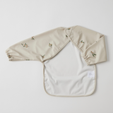 Back of Beige bib with floral print on a light grey background