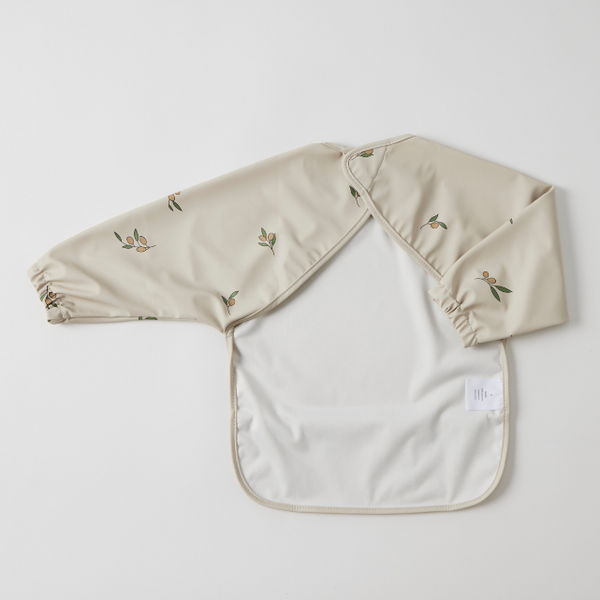 Back of Beige bib with floral print on a light grey background