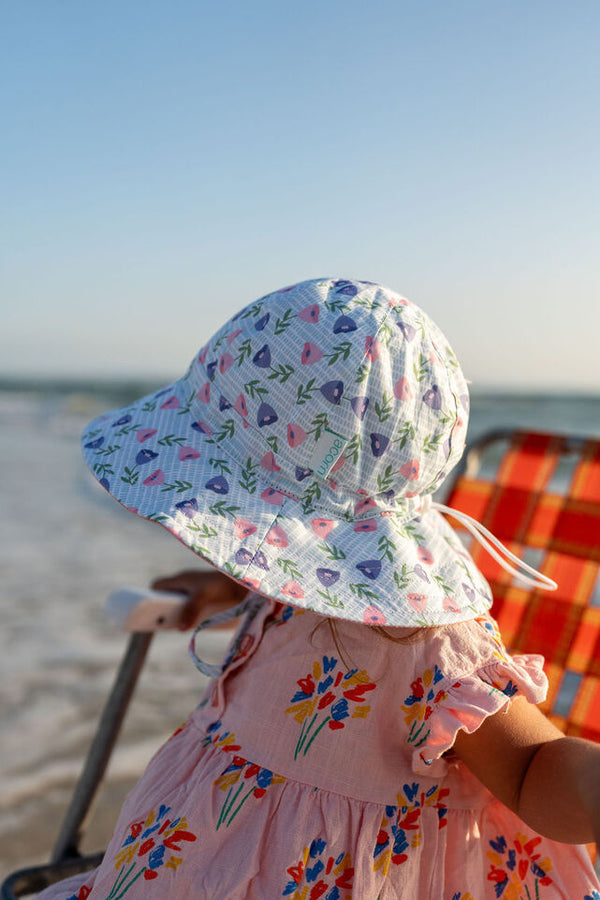 CHILD SITTING IN CHAIR AT BEACH WEARING ACORN Marigold Wide Brim Sunhat - SIDE VIEW