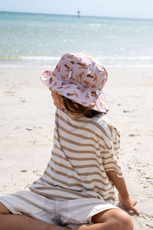 SIDE VIEW OF CHILD WEARING ACORN Aussie Sunset Wide Brim Bucket Hat AT THE BEACH