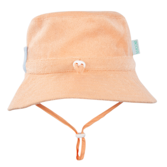Peach bucket hat with a strap on a white background