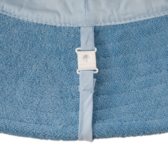 Close-up of a blue fabric with a white buckle on a white background