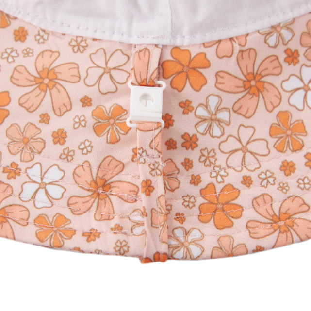 Floral-patterned fabric with orange and white flowers on a light pink background.