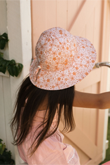Person wearing a floral-patterned hat outdoors