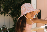 Child wearing a floral sun hat outdoors