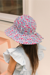 Person wearing a floral bucket hat with a blurred background
