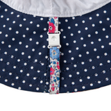 Close-up of a navy blue fabric with white polka dots and a floral strap.