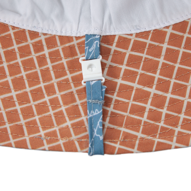Close-up of underside of hat fabric with a grid pattern and a blue tag.