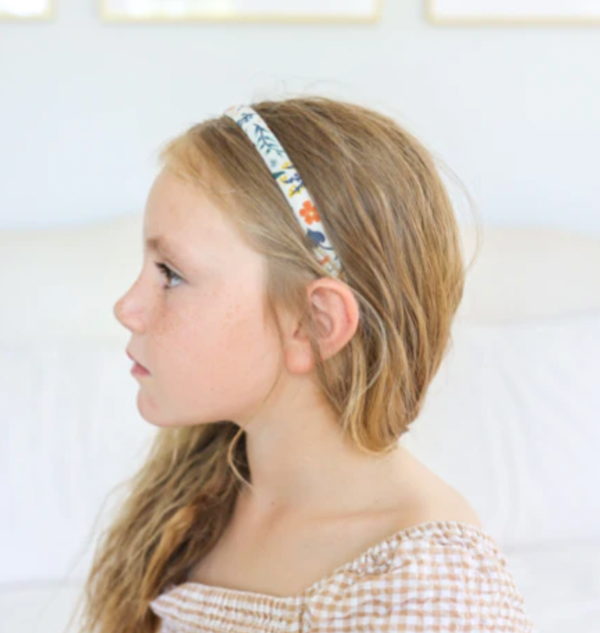 Side view of child wearing JOSIE JOAN'S Goldie Alice headband